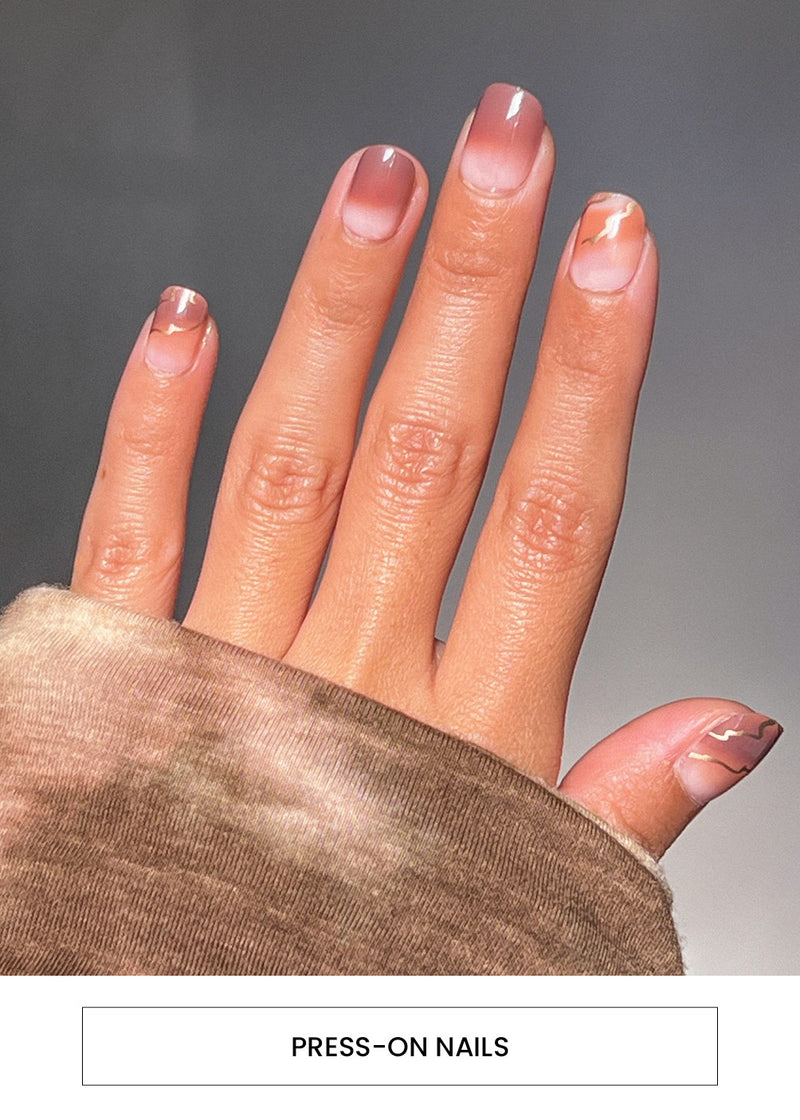 woman's hand wearing a brown design of the AOA Pro Press-on Nails alongside an "Press-On Nails" button