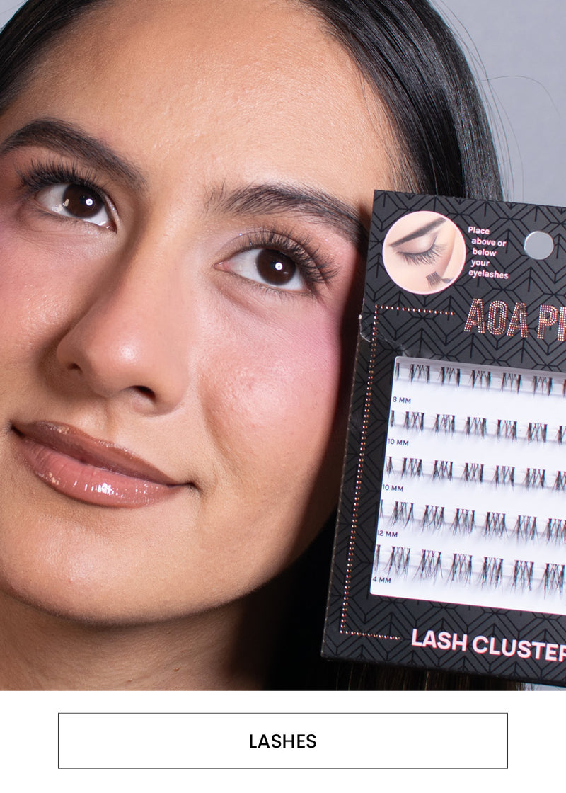 Image of a woman wearing and holding the packaging of the AOA Pro Lash Clusters alongside a “Lashes” button