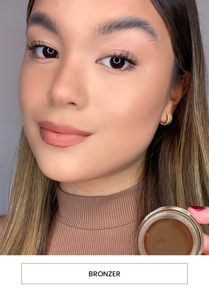 Image of a woman wearing the bronzer on her cheeks and forehead alongside a “Bronzer” button
