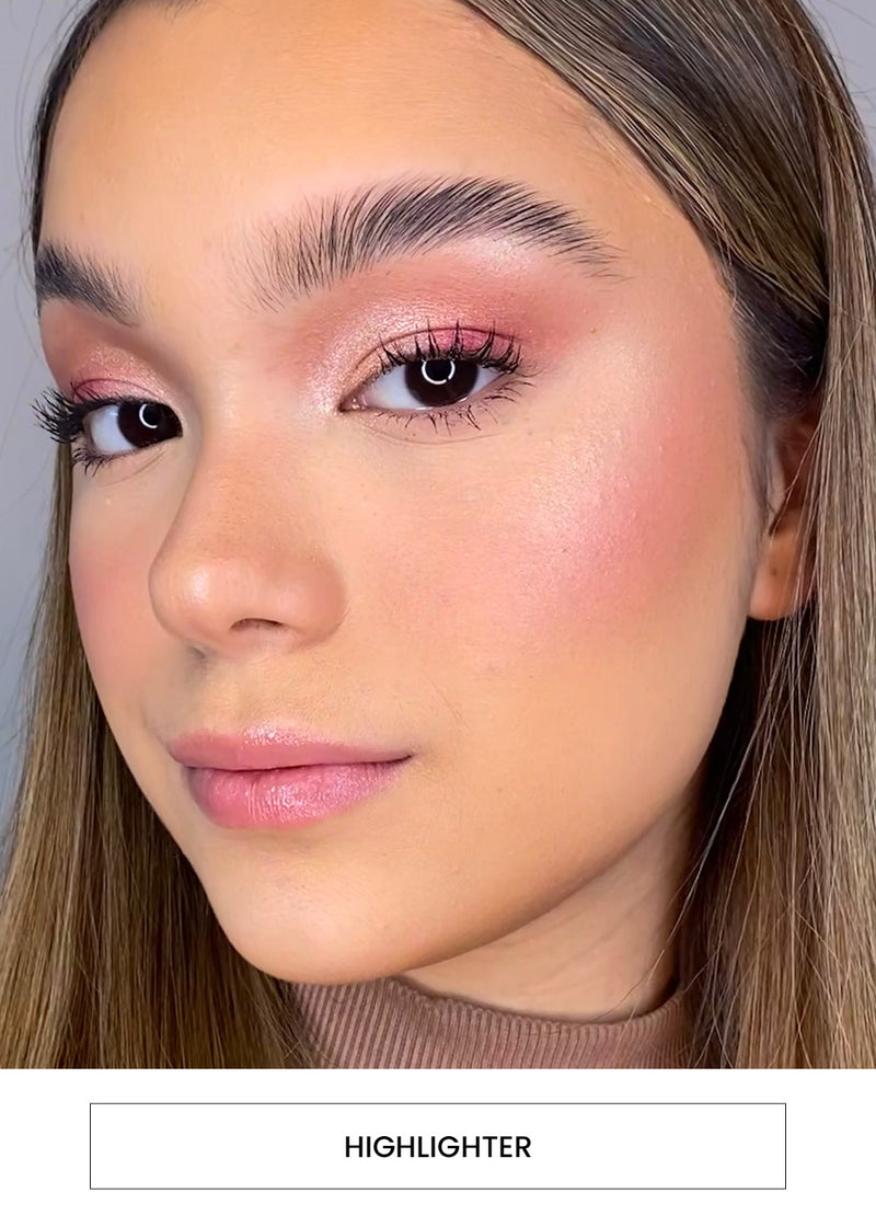 Image of a woman wearing a highlighter and pink eyeshadow makeup alongside a “Highlighter” button
