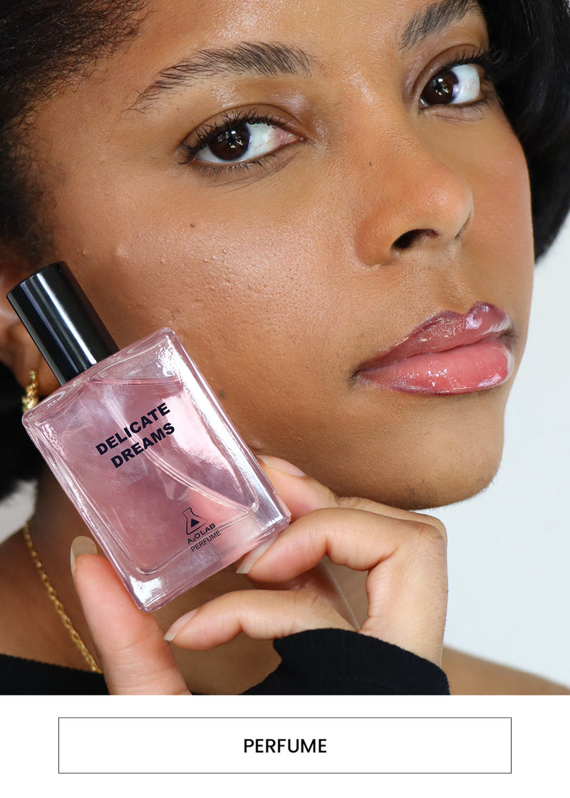Image of a woman holding an A2O Lab perfume bottle in the scent Delicate Dreams alongside a  “Perfume” button
